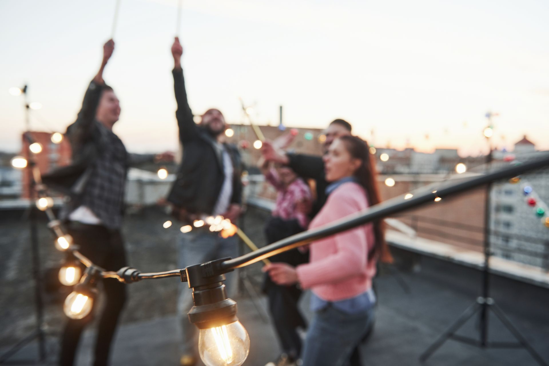 light-bulbs-is-focused-photo-playing-with-sparklers-rooftop-group-young-beautiful-friends.jpg